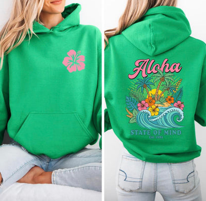 Green hoodie with pink flower design on front and tropical-themed design on back, worn by a person.